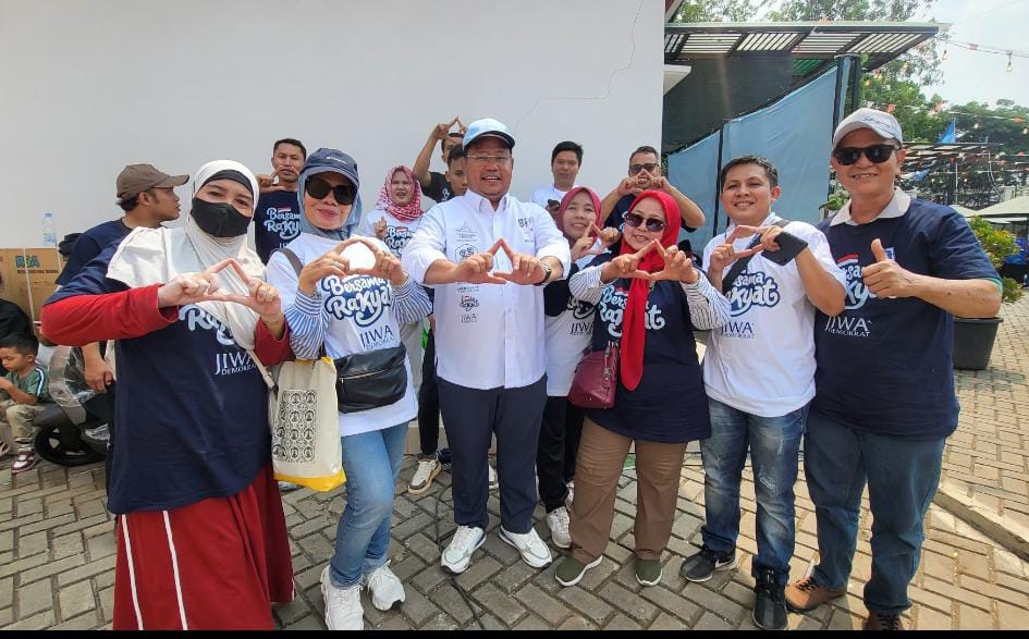 Foto : Ilham Mendrofa Ketua Panitia Lomba Rakyat Partai Demokrat (tengah) bersama para peserta dan warga yang ikut memeriahkan lomba rakyat Partai Demokrat, Minggu (23/08/2026).